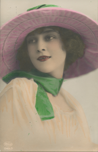 716076 Reclameprentbriefkaart (ingekleurd), met een foto van een ‘bevallige jongedame’ met een modieuze hoed op het ...